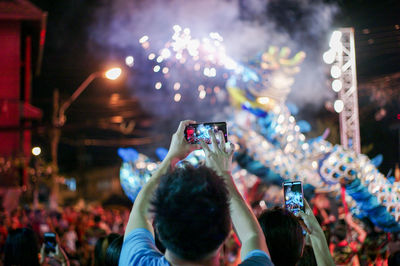 Group of people photographing at night