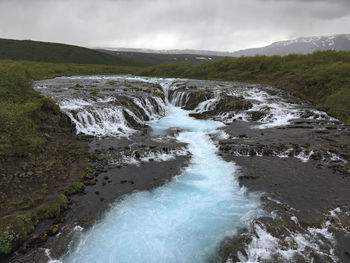 Scenic view of waterfall against sky