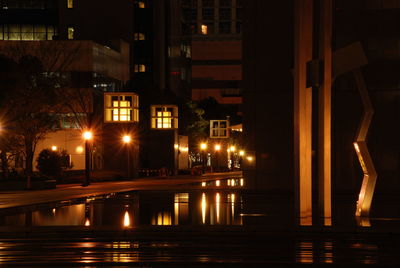 Illuminated buildings by street at night