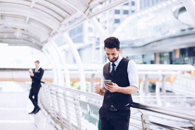 Full length of young man using mobile phone