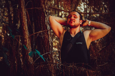 Young man looking away in forest