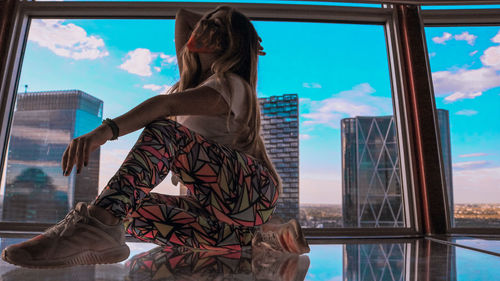 Rear view of woman looking at swimming pool against sky