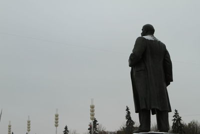 Rear view of men standing against clear sky