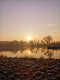 Scenic view of lake against sky during sunset