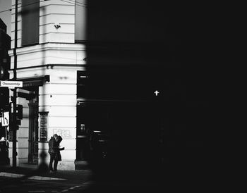 Rear view of woman walking on illuminated city at night