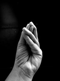 Cropped image of hand against black background