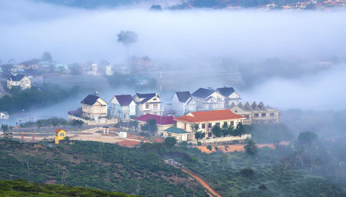 High angle view of buildings and trees against sky