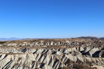 Scenic view of rocky mountains against clear blue sky