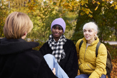 Three friends in park in autumn scenery