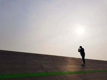 Silhouette man standing against sky during sunset