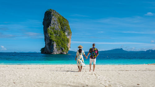 Couple holding hands standing on beach