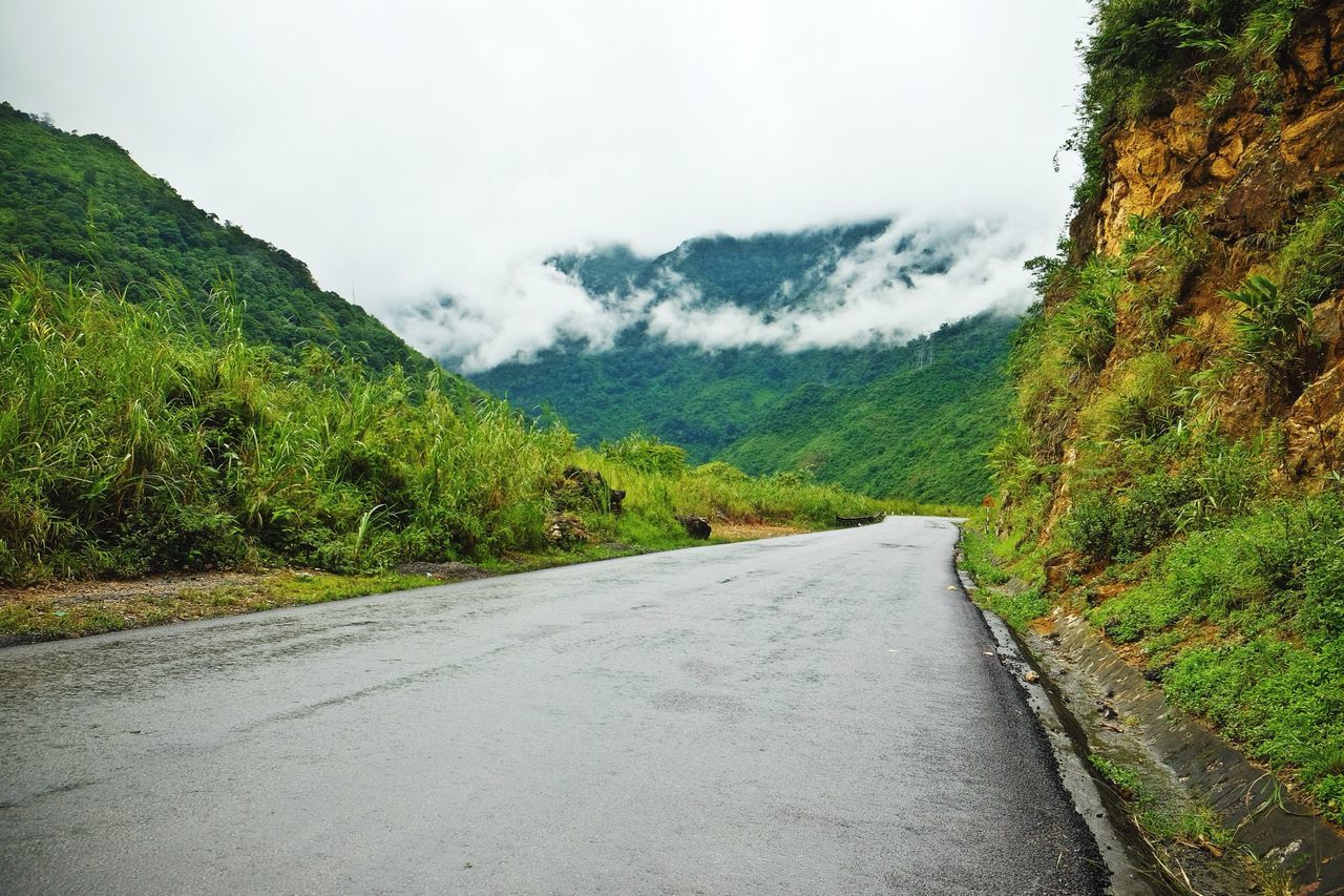 mountain, sky, tranquil scene, tranquility, scenics, tree, mountain range, road, beauty in nature, the way forward, nature, green color, landscape, non-urban scene, day, idyllic, country road, countryside, cloud - sky, remote