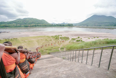 High angle view of monks carrying wood on steps