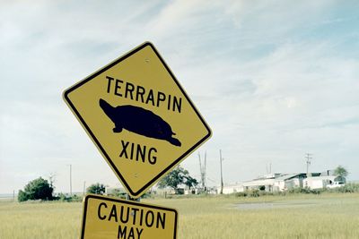 Information sign on road against sky