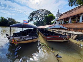 Boats moored in canal against sky