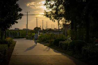 Man riding bicycle on road against sky