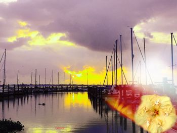 Boat in sea against cloudy sky at sunset