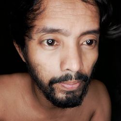 Close-up portrait of shirtless young man