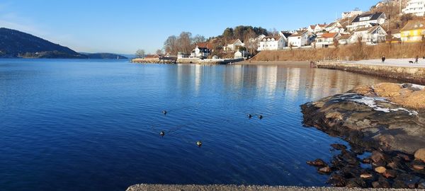 Scenic view of lake and buildings against sky