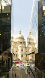 Reflection of church on modern office building in city