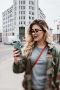 Young woman using smart phone in city