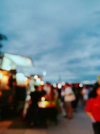 Defocused image of illuminated city against sky at night