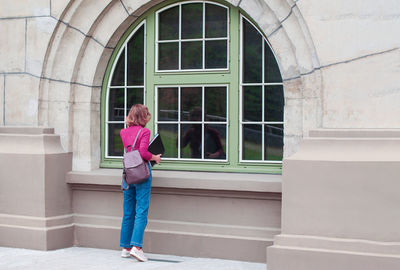 Young caucasian girl going back to college, school, standing with a notebooks