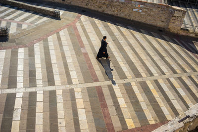 High angle view of woman walking on cobblestone street