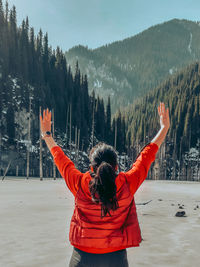 Rear view of woman standing on snow covered mountain