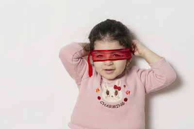 Portrait of cute girl standing against white background