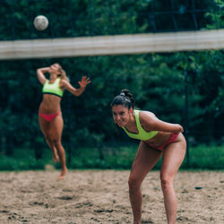 Beach volleyball, female player serving the ball