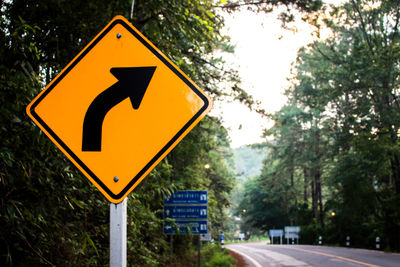 Low angle view of road sign against trees