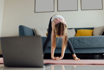 Low section of woman using laptop at home