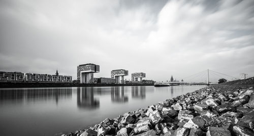 City buildings by sea against sky