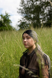 Portrait of young woman looking away on field