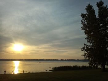 Reflection of trees in lake at sunset