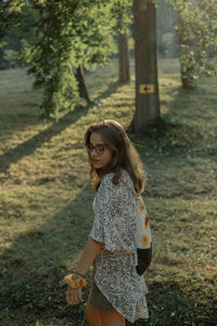 Side view of young woman walking on grass land