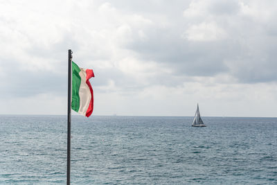 Low angle view of flag on sea against sky