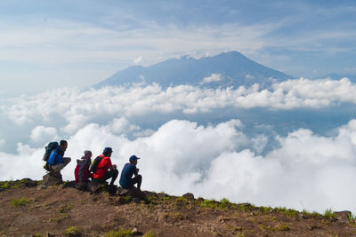 People on mountain against sky