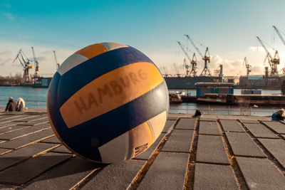 Commercial dock by river against sky. closeup volleyball in the front