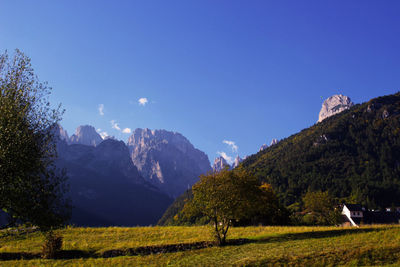 Scenic view of landscape and mountains against blue sky