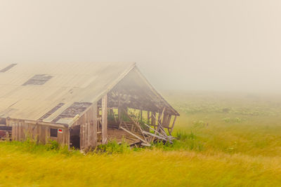 Abandoned built structure on field against clear sky