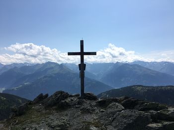 Cross on mountains against sky