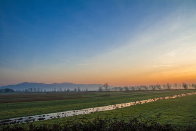 Scenic view of field against sky during sunset