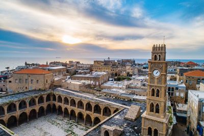 High angle view of buildings in town against cloudy sky