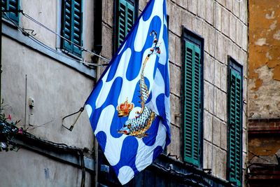 Low angle view of flag against buildings in city