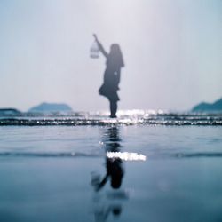 Silhouette man on beach against sky