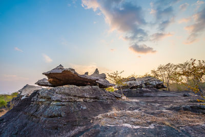 Rock formation on snow against sky during sunset