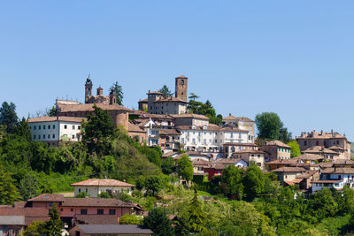 Buildings in town against clear blue sky