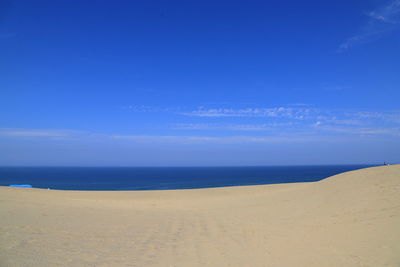 Scenic view of beach against blue sky